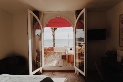 a mirror in a bedroom with a view of the ocean at Rose Thé in La Ciotat