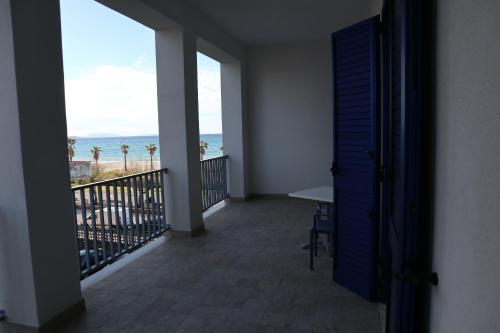 a room with a balcony with a view of the ocean at Karma Resort in Venetico