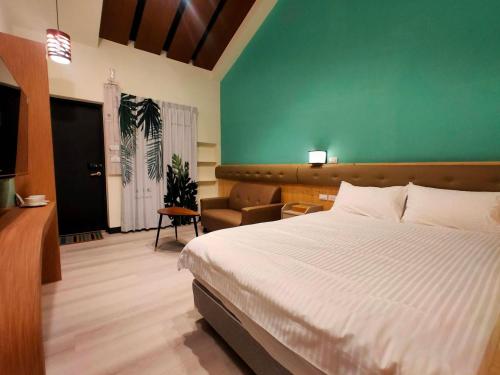 a bedroom with a bed and a green wall at 山淺民宿 Yamasaki Old House in Taiping