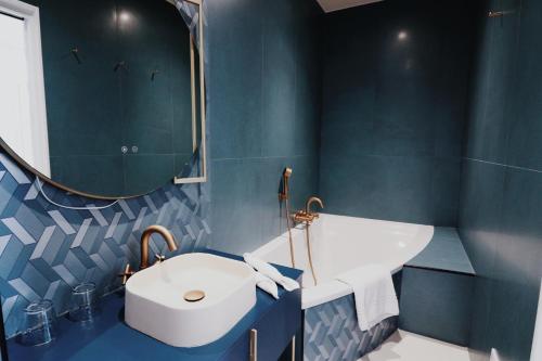 a bathroom with a white sink and a mirror at Le Rose Thé in La Ciotat
