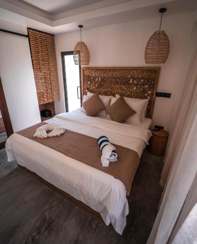 a bedroom with a large bed with a towel on it at kunaa beach Inn in Fulidhoo