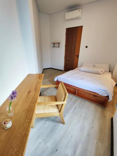a bedroom with a bed and a wooden table at Beautiful House in City Centre in Kanggraksan