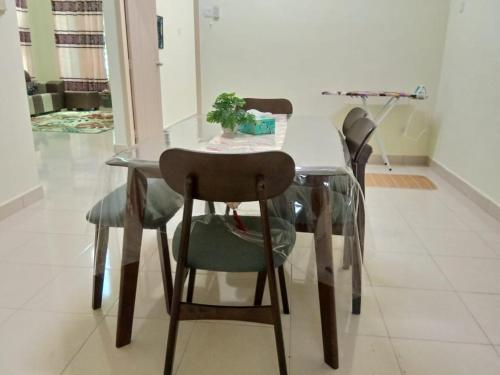 a dining room table and chairs with a glass table at Family Homestay Taman Vistana Indah Alor Setar in Langgar