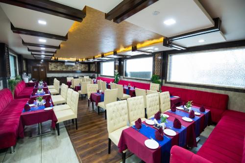 a restaurant with red and blue tables and chairs at The Fern Residency Katra in Katra