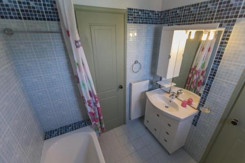 a bathroom with a sink and a mirror and a tub at Watermill Villa in Svoronata
