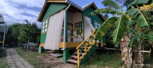a house with a green and yellow facade at Hotel YELLOW HOME Providencia Isla in Providencia