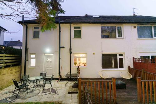 a house with a patio with chairs and a table at West Park House in Bramhope