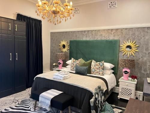 a bedroom with a large bed with a chandelier at Smithgrove Guesthouse in Pietermaritzburg