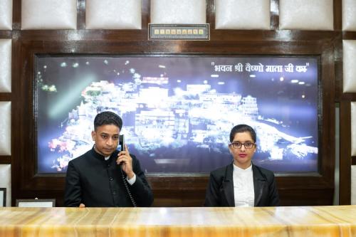 two men in front of a screen with a cell phone at The Fern Residency Katra in Katra