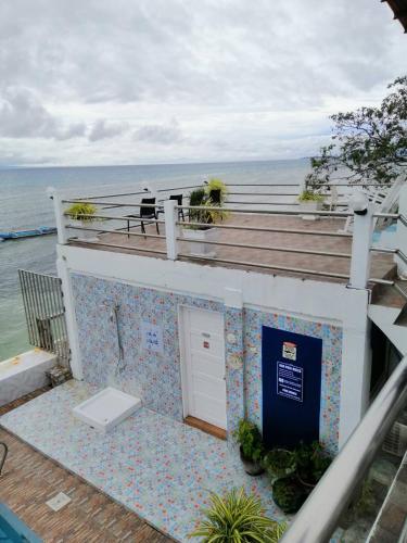 a bathroom with a toilet on a building next to the ocean at Germaroze in Oslob