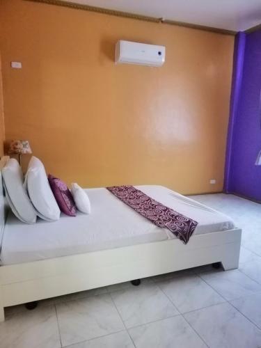 a bed with pillows on it in a room at Germaroze in Oslob