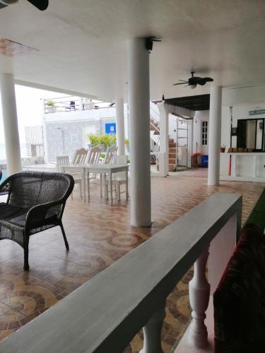 a room with a table and chairs and a bench at Germaroze in Oslob