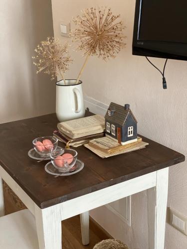 a table with a small house and a vase at B&B MELLONI STREET in Dolo