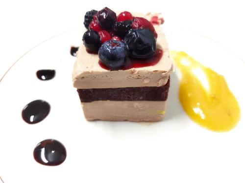 a piece of cake with fruit on a plate at Hotel Santa Cecilia in Ciudad Real