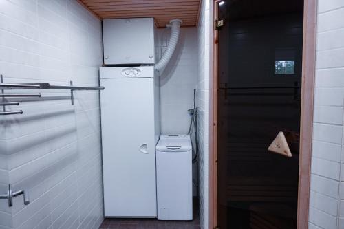 biała lodówka w pokoju z drzwiami w obiekcie Holiday Home Tokka at Iso-Syöte w mieście Syöte