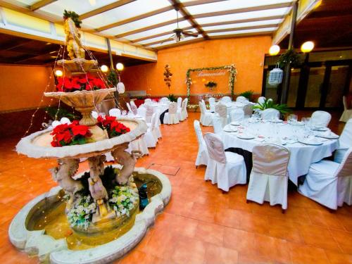 a banquet hall with white tables and a large fountain at Hotel Santa Cecilia in Ciudad Real