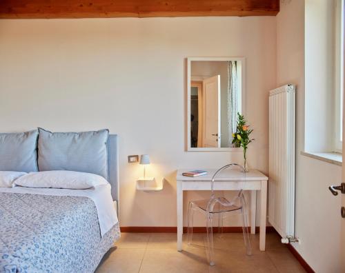 a bedroom with a bed and a table and a mirror at Country House Ca'Balsomino in Urbino