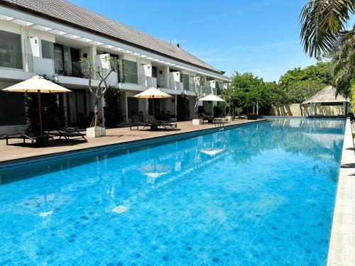 a large blue swimming pool next to a building at The Wangsa Benoa in Nusa Dua