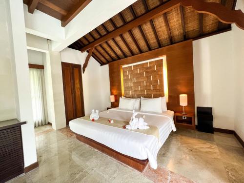 a bedroom with a large bed with white sheets at The Wangsa Hotel and Villas Benoa in Nusa Dua