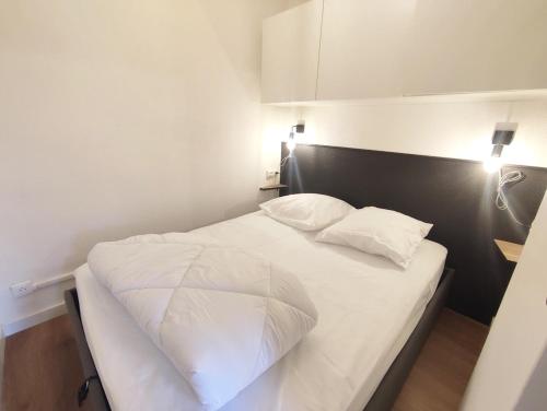 sypialnia z białym łóżkiem i dwiema poduszkami w obiekcie Le cerf charmant, T2, Luchon, wifi, balcon, ascenseur, 4 personnes w mieście Luchon