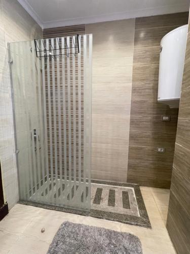 a shower with a glass door in a bathroom at Awesome Villa on a hill Families only in Cairo