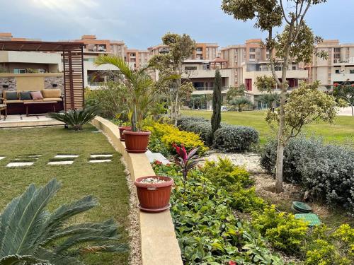 a garden with flowers and plants in a city at Awesome Villa on a hill Families only in Cairo