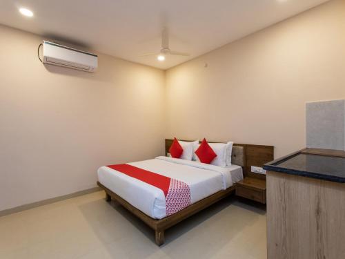 ムンバイにあるOYO Flagship 80644 Hotel Noble Palaceのベッドルーム1室(赤い枕のベッド1台付)