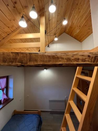 a loft bed in a room with a blue bunk bed at Ličke radosti in Lapac Gornji