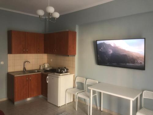 a kitchen with a sink and a table and a tv at REM One Bedroom Apartment in Thessaloniki