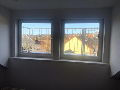 two windows in a room with a view of a building at Brynmill Flat in Swansea