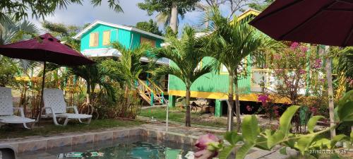 a house with a swimming pool in front of a house at Hotel YELLOW HOME Providencia Isla in Providencia