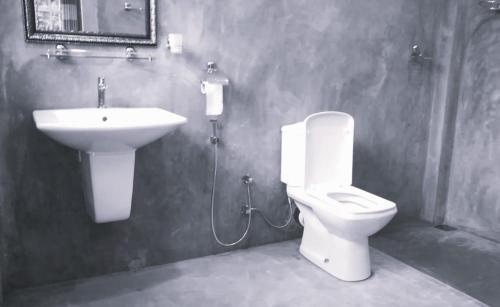 a bathroom with a toilet and a sink at Sinharaja Vini Villa in Deniyaya