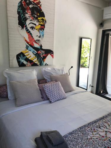 1 dormitorio con 1 cama grande y una pintura en la pared en Villa les 3 lumières 8-10 personnes, Clim, piscine à proximité des plages, en La Ciotat