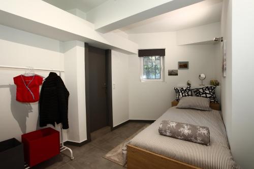 1 dormitorio con 1 cama y 1 silla roja en Nefeli, en Atenas