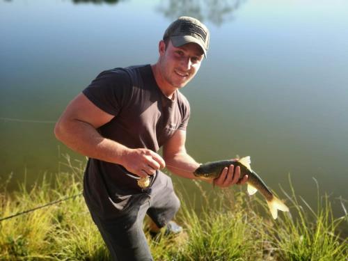 a man holding a fish in a field at Imbabali Retreat & Venue in Magaliesburg