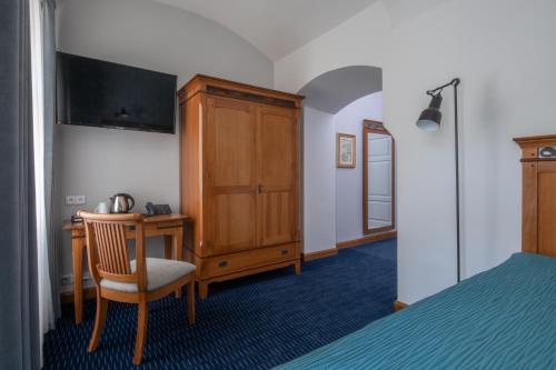 a bedroom with a desk and a cabinet and a bed at Monastery Garden Prague in Prague