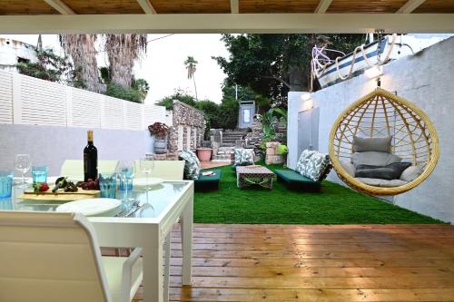 a patio with a table and chairs and a swing at Atlantis luxury apartment first line to sea of galelli in Tiberias