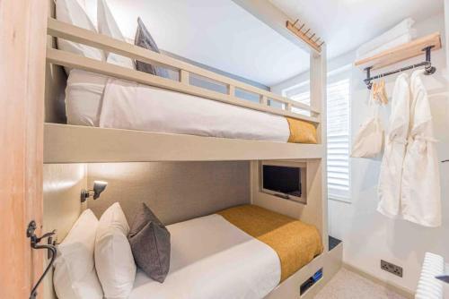 a bedroom with two bunk beds with a tv at Teapot Cottage in Ennerdale - Hot tub Pizza Oven Log Burner in Cleator