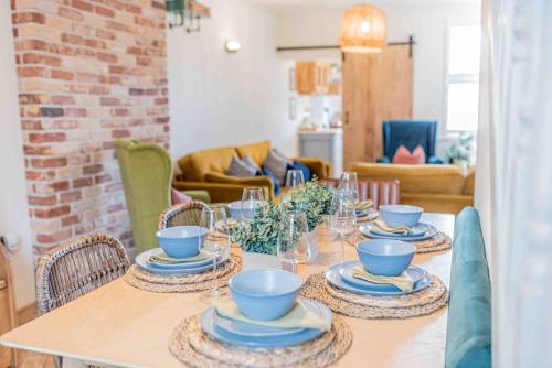 a dining room table with blue bowls and plates on it at Teapot Cottage in Ennerdale - Hot tub Pizza Oven Log Burner in Cleator