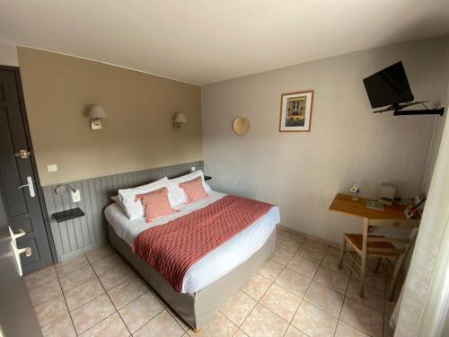 een slaapkamer met een bed, een bureau en een televisie bij Hôtel Restaurant Le Clos Charmant in Vallon-Pont-dʼArc