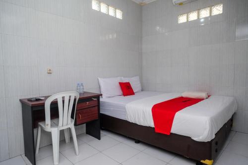 a bedroom with a bed and a desk and a chair at RedDoorz near Danurejan Malioboro in Yogyakarta