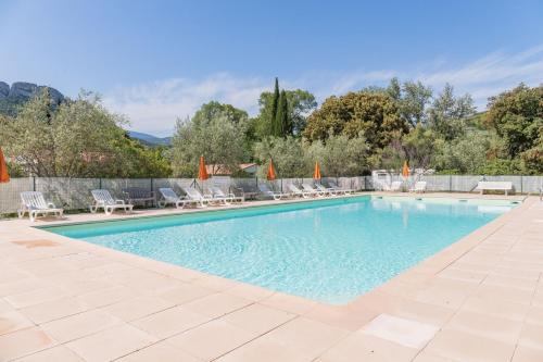 uma piscina com cadeiras e guarda-sóis em LA FONTAINE D'ANNIBAL em Buis-les-Baronnies