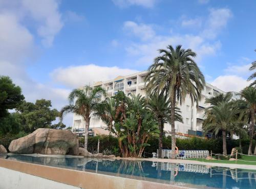 ein Hotel mit Palmen und einem Pool in der Unterkunft Apartemento SOL in Alcossebre