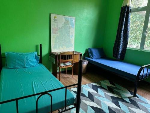 a room with two beds and a green wall at Inap@Rusa in Bachok