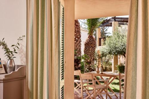a room with a patio with a table and chairs at Candia Park Village in Agios Nikolaos