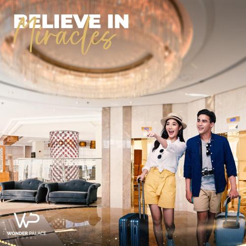 a man and woman standing in a lobby with luggage at Wonder Palace Hotel Qatar in Doha