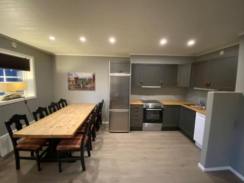 a kitchen with a wooden table with chairs and a refrigerator at Jotunheimen/Besseggen/7ppl/View/Amazing hikes in Randsverk