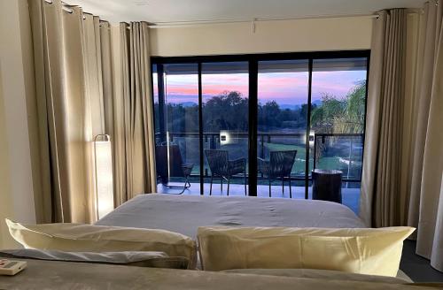 a bedroom with a bed and a large glass window at I love phants Lodge in Ban Huai Thawai