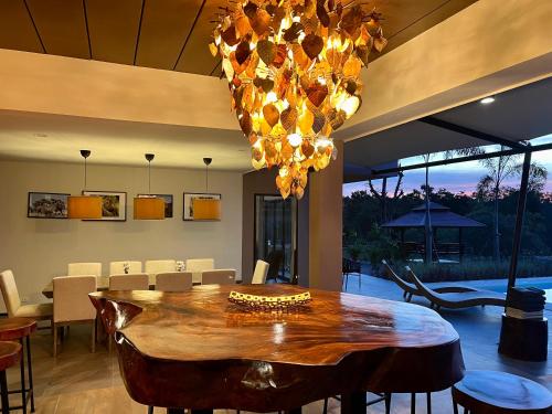 a dining room with a table and a chandelier at I love phants Lodge in Ban Huai Thawai