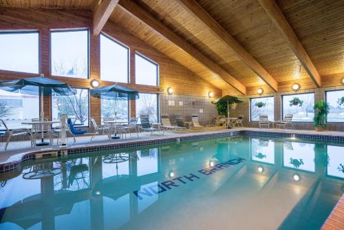 a swimming pool in a large building with windows at AmericInn by Wyndham North Branch in North Branch